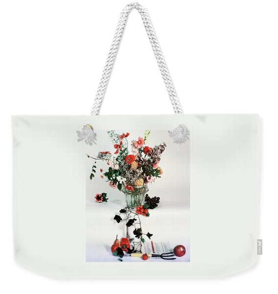 A Studio Shot Of A Vase Of Flowers And A Garden Weekender Tote Bag