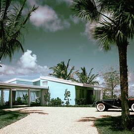 A Vintage Car Parked Outside A Blue House by Tom Leonard