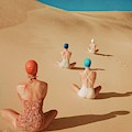 Models Sitting On Sand Dunes
