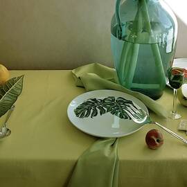 Plates, Apples And A Vase On A Green Tablecloth by Horst P. Horst